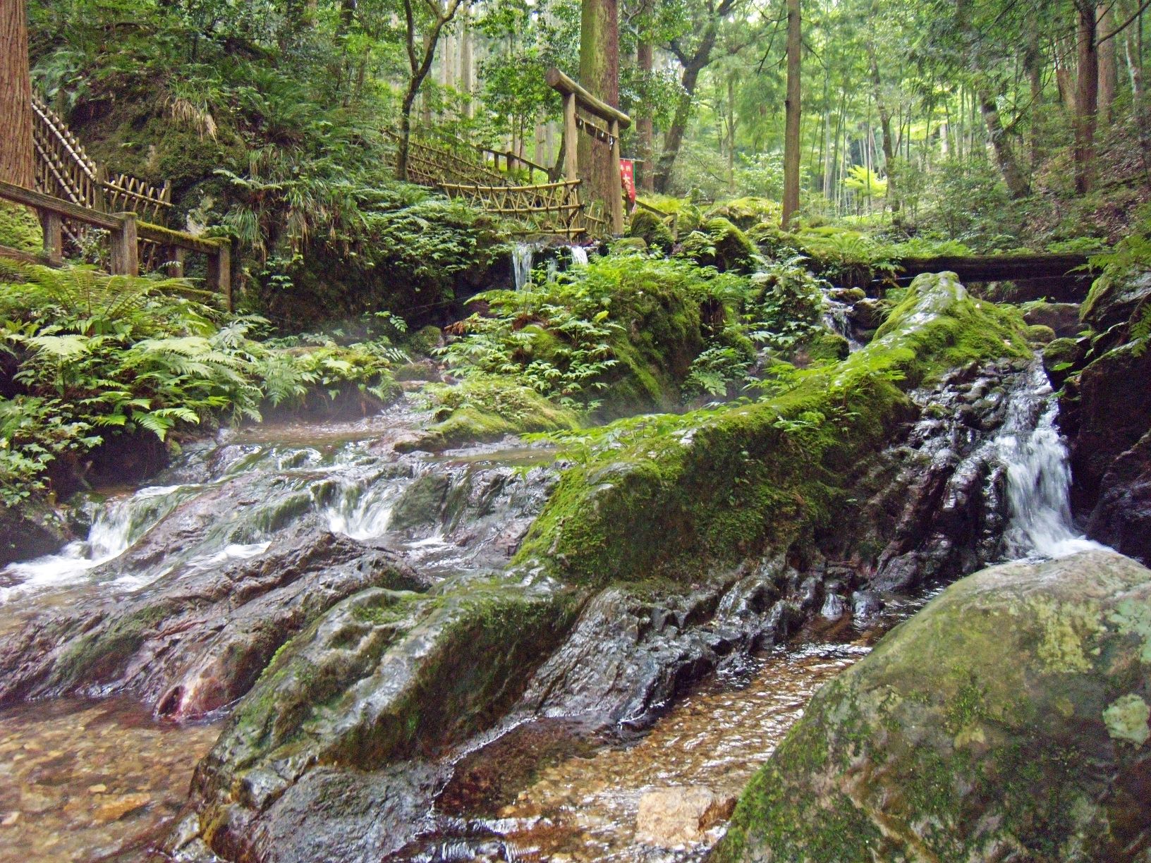 福井県の爪割りの滝の写真。湧き水がゴツゴツした岩の斜面に沿って滝のように激しく流れています。